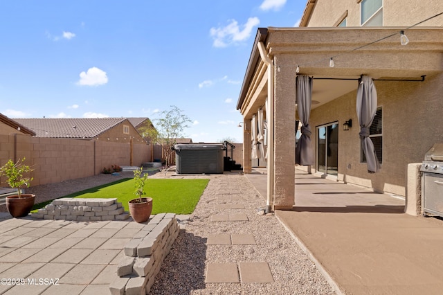 view of yard with a patio area, a hot tub, and a fenced backyard