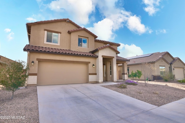 mediterranean / spanish-style home featuring stucco siding, concrete driveway, an attached garage, and a tile roof