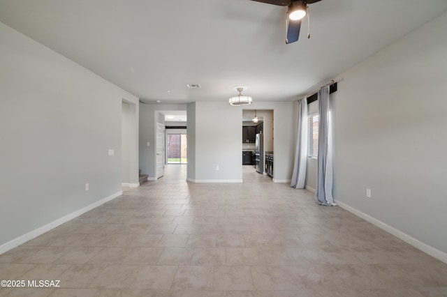 empty room with a healthy amount of sunlight, baseboards, and ceiling fan