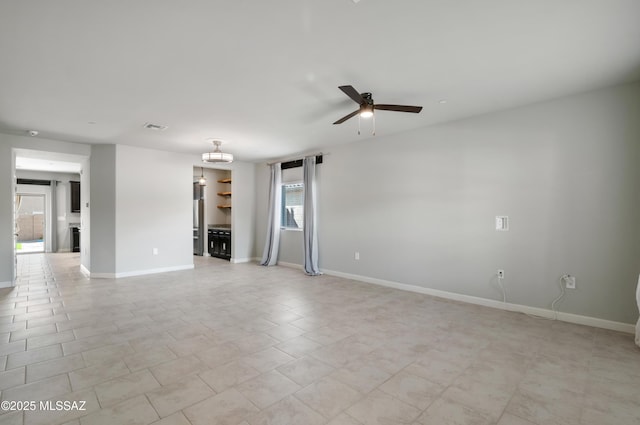 empty room featuring baseboards, visible vents, and ceiling fan