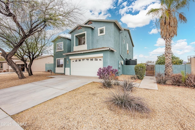 traditional-style home with stucco siding, a gate, fence, a garage, and driveway