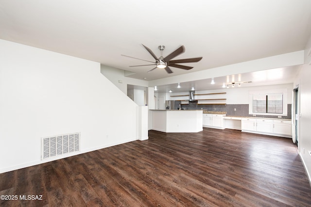 unfurnished living room featuring ceiling fan, dark wood-style flooring, visible vents, and baseboards