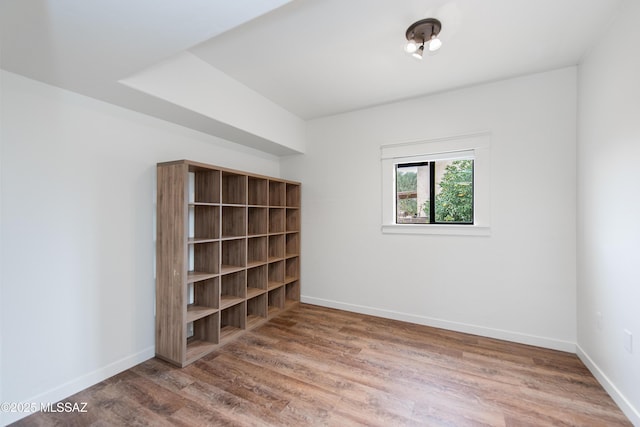 unfurnished room with baseboards and wood finished floors