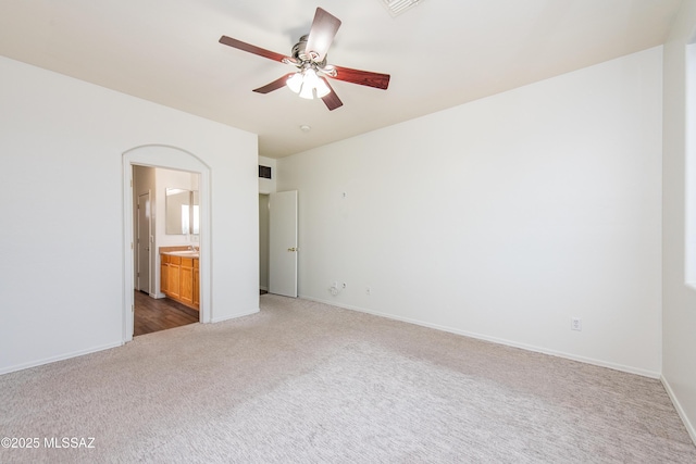 unfurnished bedroom featuring ceiling fan, carpet flooring, connected bathroom, and baseboards