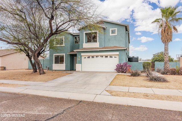 traditional-style home with concrete driveway, fence, an attached garage, and stucco siding