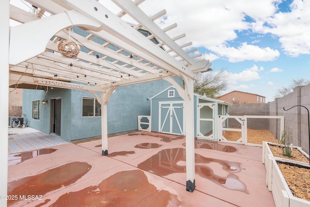 view of patio with an outbuilding, a vegetable garden, a storage shed, a pergola, and a fenced backyard