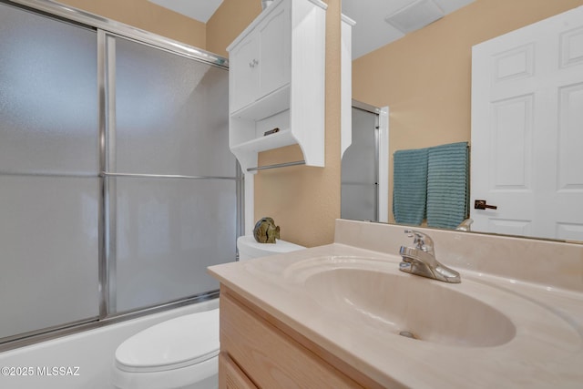 full bath featuring vanity, toilet, and shower / bath combination with glass door