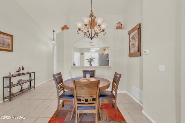 dining area with visible vents, baseboards, an inviting chandelier, light tile patterned flooring, and arched walkways