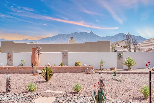 exterior space featuring a mountain view and a fenced front yard