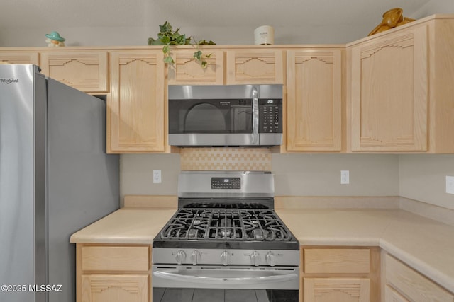 kitchen featuring light countertops, light brown cabinets, backsplash, and stainless steel appliances