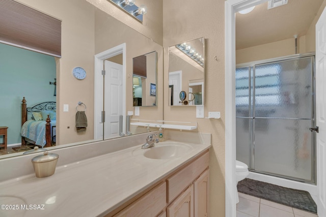 ensuite bathroom with tile patterned flooring, connected bathroom, toilet, a stall shower, and vanity