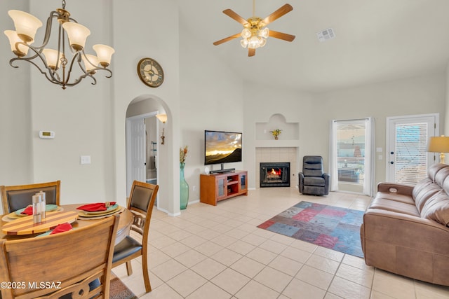 living room with light tile patterned floors, visible vents, a tile fireplace, and arched walkways