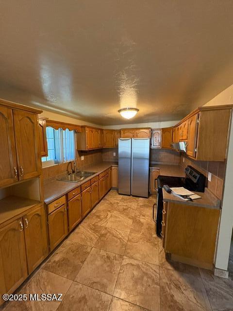 302 W Aragon Rd, Tucson, AZ 85756 - kitchen featuring freestanding refrigerator, a sink, black range with electric stovetop, brown cabinetry, and exhaust hood