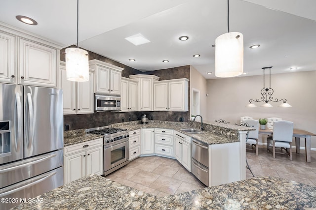 kitchen featuring tasteful backsplash, a breakfast bar, dark stone counters, appliances with stainless steel finishes, and a sink