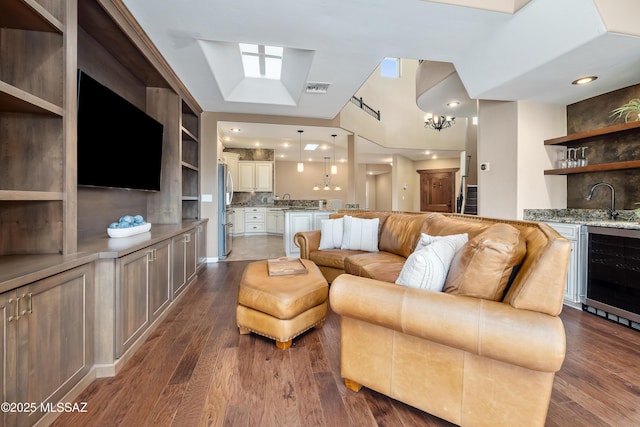 living room featuring wet bar, dark wood-style floors, beverage cooler, and visible vents