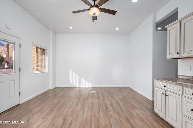 unfurnished dining area with ceiling fan, recessed lighting, light wood-type flooring, and baseboards