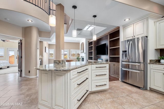 kitchen with open floor plan, dark stone counters, stainless steel refrigerator with ice dispenser, and a ceiling fan