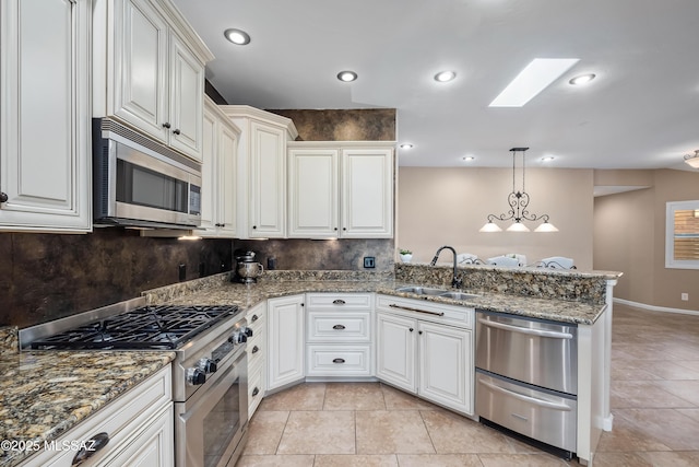 kitchen with decorative backsplash, recessed lighting, appliances with stainless steel finishes, a peninsula, and a sink