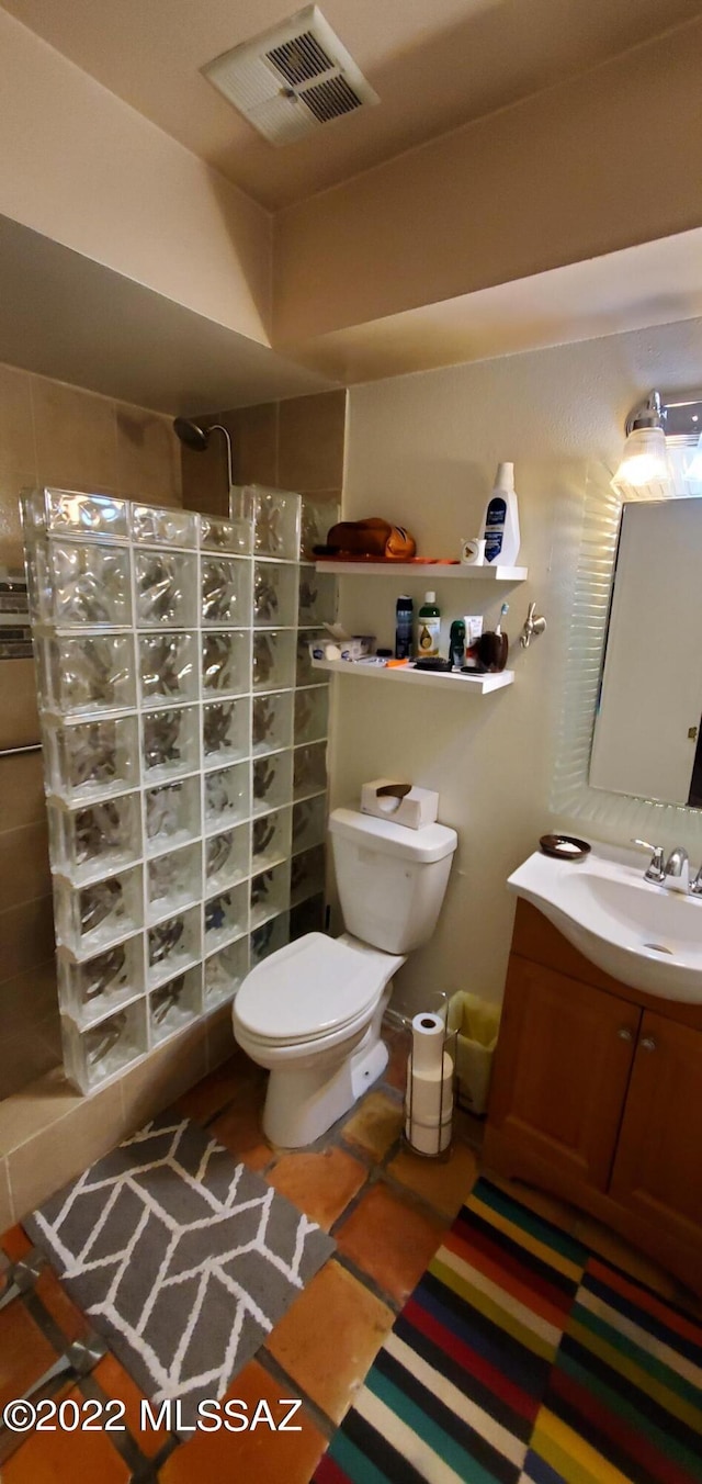 full bath featuring toilet, visible vents, walk in shower, and vanity