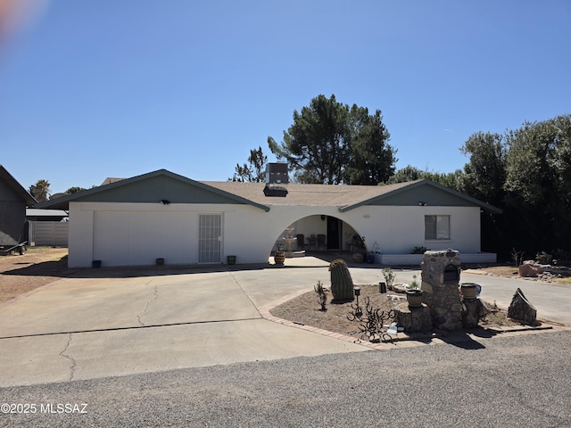 ranch-style home with a garage, driveway, and central AC unit