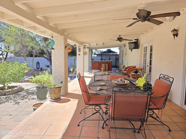 view of patio / terrace featuring a ceiling fan, french doors, fence, and outdoor dining area