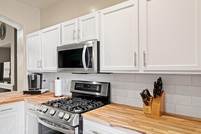 kitchen featuring wood counters, appliances with stainless steel finishes, and white cabinets