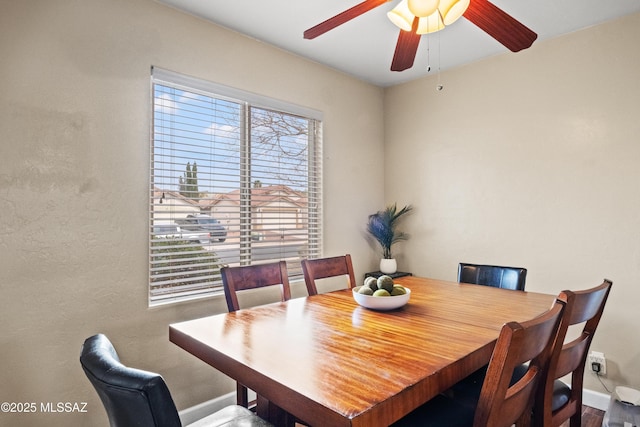 dining space with a ceiling fan and baseboards