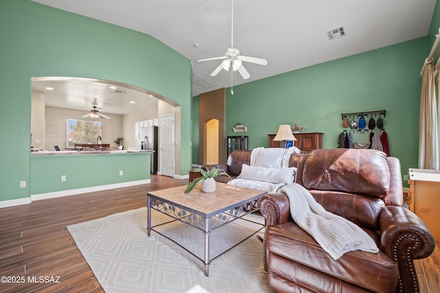 living room with visible vents, arched walkways, lofted ceiling, ceiling fan, and wood finished floors