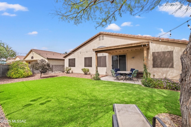 back of property with a patio area, a lawn, fence, and stucco siding