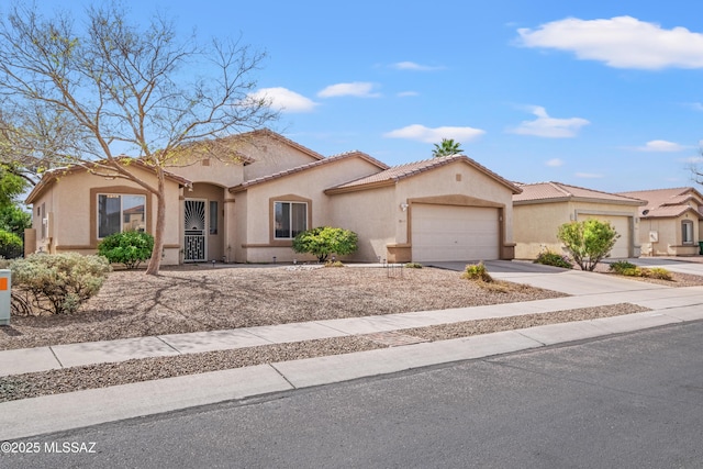 mediterranean / spanish home featuring a garage, a tiled roof, concrete driveway, and stucco siding
