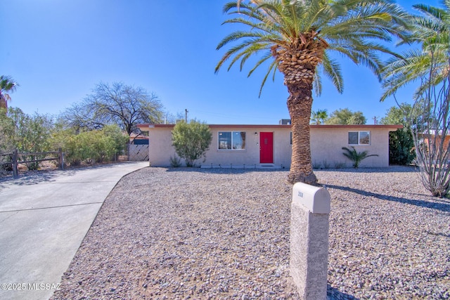 ranch-style home with fence and stucco siding