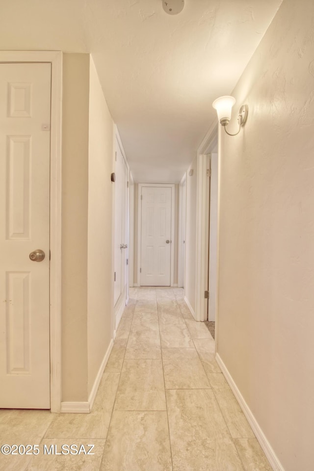 hallway featuring baseboards