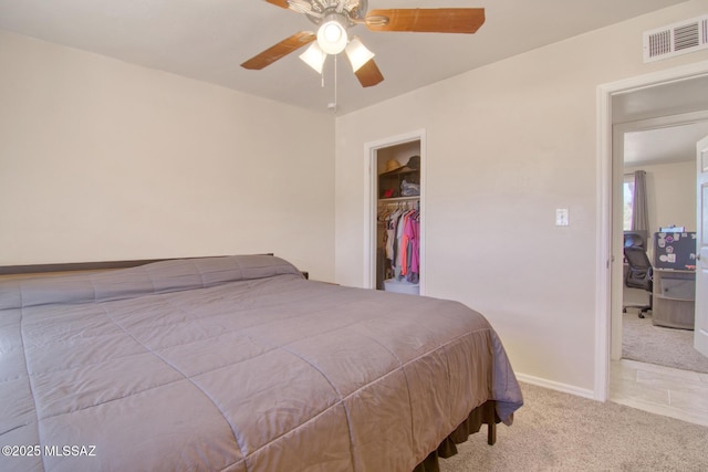 carpeted bedroom featuring a closet, visible vents, a spacious closet, a ceiling fan, and baseboards