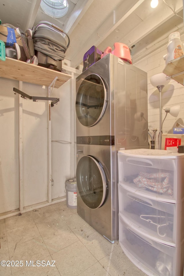 laundry room featuring stacked washer and dryer, laundry area, and tile patterned floors