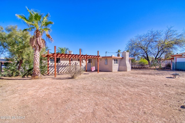 back of house featuring stucco siding, fence, and a pergola