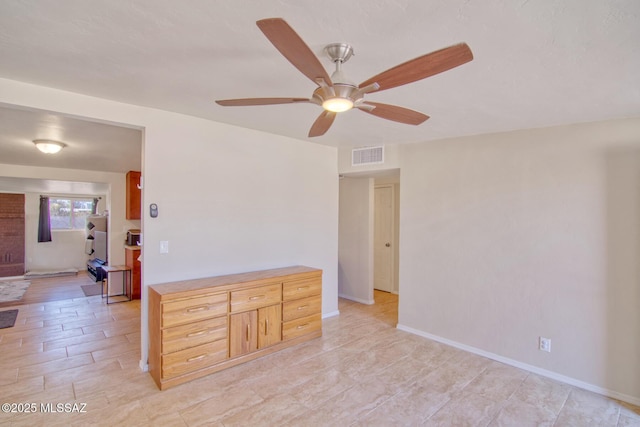 empty room with a ceiling fan, visible vents, and baseboards