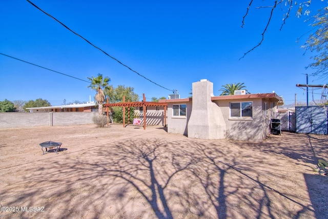 back of property featuring fence and stucco siding