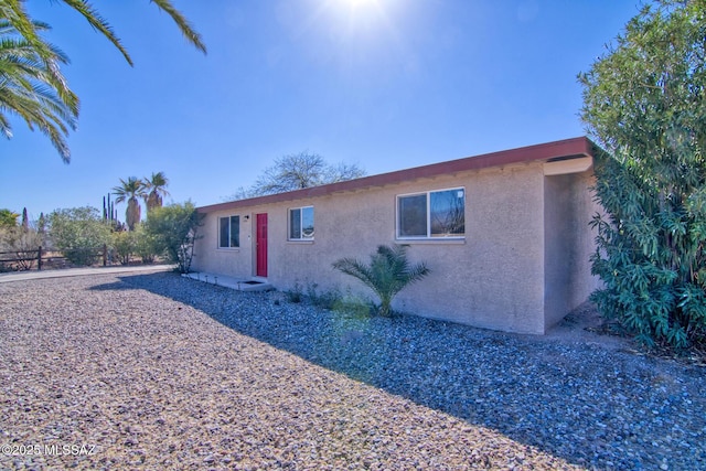 view of front of home featuring fence and stucco siding