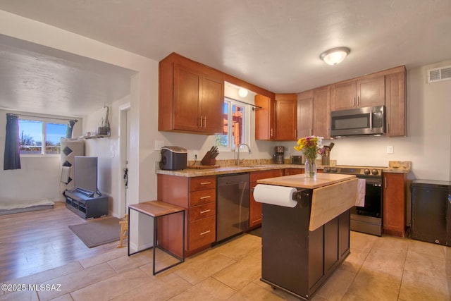 kitchen with stainless steel appliances, a healthy amount of sunlight, light countertops, and visible vents