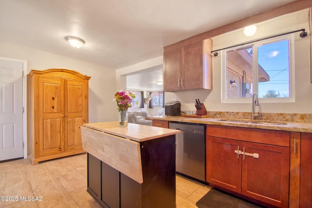 kitchen featuring a center island, light tile patterned floors, brown cabinetry, a sink, and dishwasher