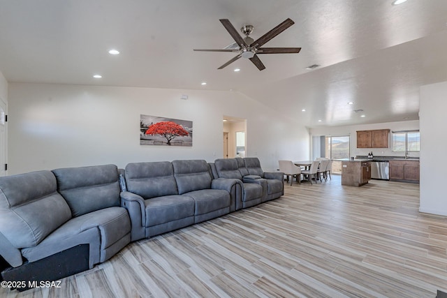 living room with ceiling fan, recessed lighting, visible vents, vaulted ceiling, and light wood-type flooring