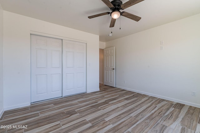 unfurnished bedroom with a closet, light wood-type flooring, a ceiling fan, and baseboards