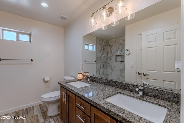 bathroom featuring a healthy amount of sunlight, visible vents, a sink, and toilet