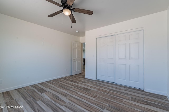 unfurnished bedroom featuring ceiling fan, wood finish floors, a closet, and baseboards