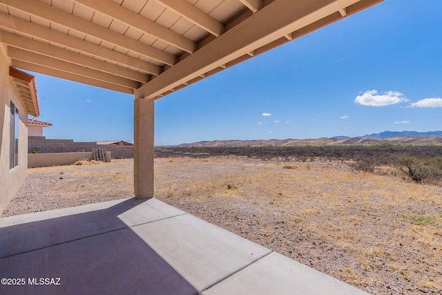 view of patio featuring a mountain view and fence