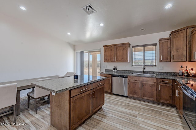 kitchen with visible vents, electric range oven, a sink, dishwasher, and a kitchen bar