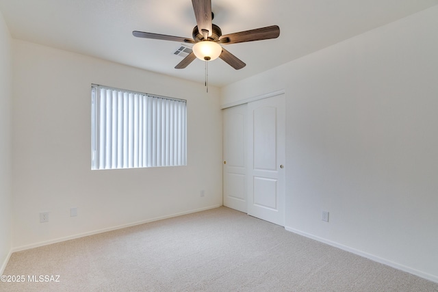 carpeted empty room featuring a ceiling fan, baseboards, and visible vents