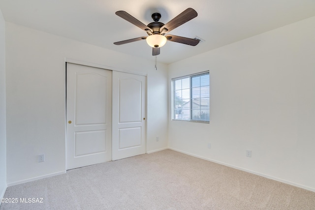 unfurnished bedroom featuring a closet, ceiling fan, baseboards, and carpet