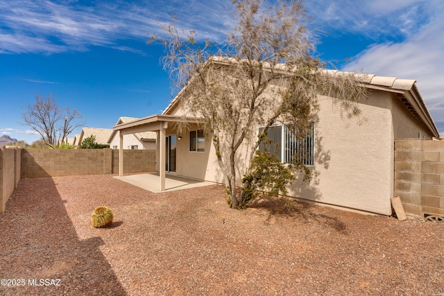 back of property with stucco siding, a patio, and a fenced backyard