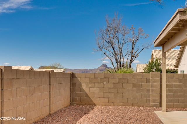 view of yard featuring a mountain view and fence